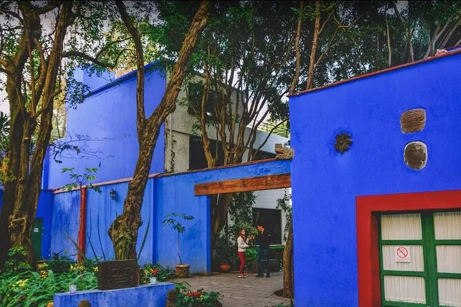 Small group of visitors outside the bright blue walls of Casa Azul on a Frida Kahlo Blue House skip-the-line guided tour, Mexico City